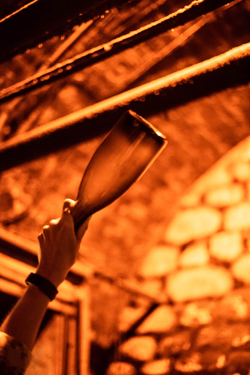 Champagne bottle held up to the light showing the lees deposit before disgorging